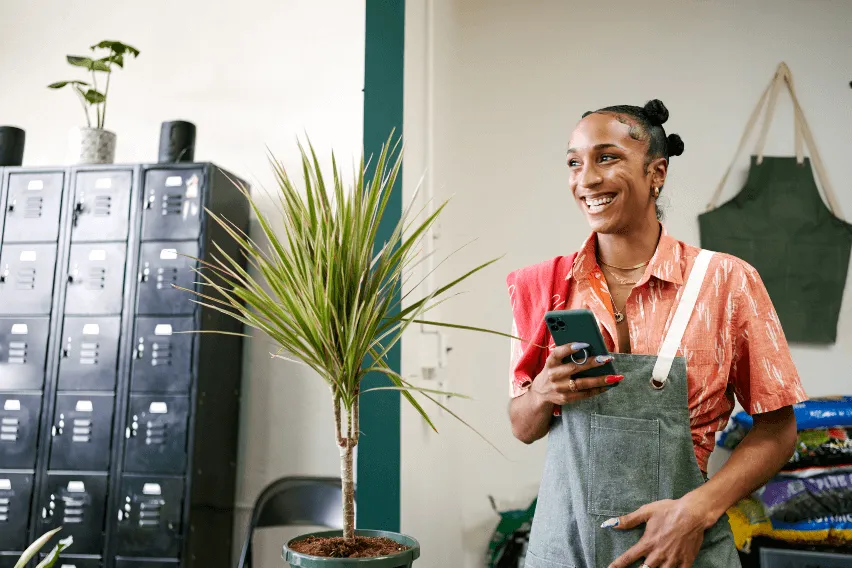 Woman wearing apron smiles while looking out of the frame